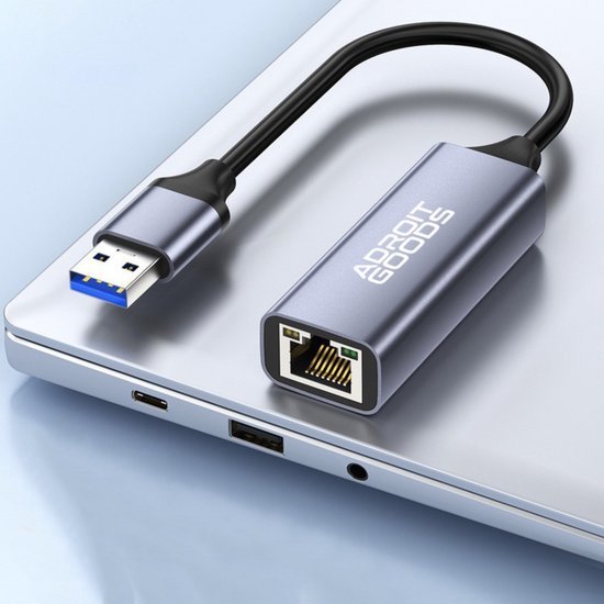 USB naar Ethernet adapter met metalen behuizing en geïntegreerde kabel op laptop geplaatst