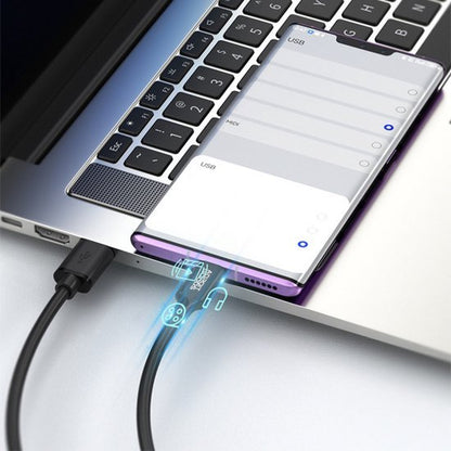 Smartphone verbonden met laptop via een kabel voor datatransmissie en muziekweergave.