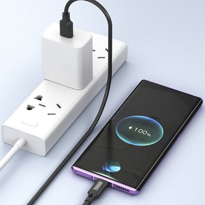 Smartphone die via een zwarte kabel volledig wordt opgeladen met een wit stopcontactblok