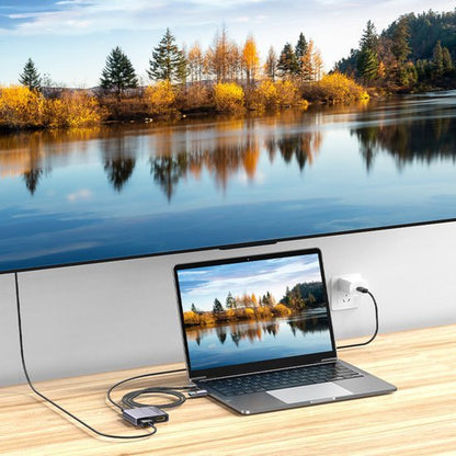 Laptop verbonden met groot scherm, beeld van herfstlandschap met bomen en waterreflecties weergegeven