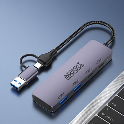 luxe grijze hub met meerdere usb poorten en een kort gevlochten kabeltje naast laptop