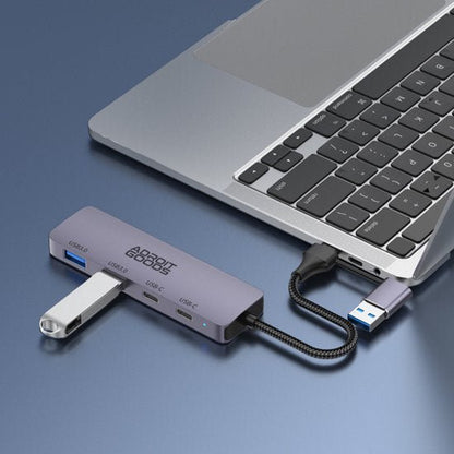 AdroitGoods USB-hub aangesloten op laptop met meerdere USB- en USB-C poorten in grijsvlak
