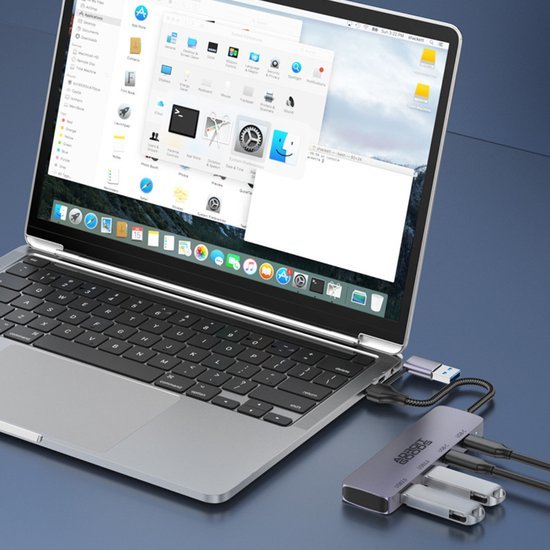 Laptop met aangesloten USB-hub met meerdere poorten op een blauwe ondergrond
