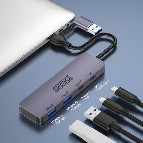 Donkergrijze USB-hub aangesloten op laptop met meerdere USB- en Type-C kabels aangesloten