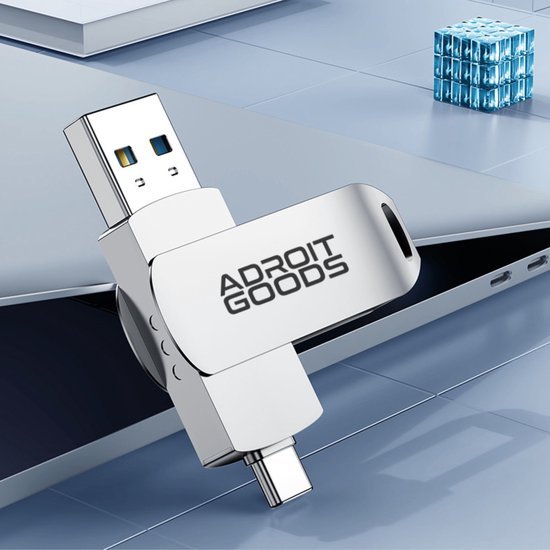 Usb-stick met draaibare metalen behuizing en AdroitGoods logo op een laptop geplaatst