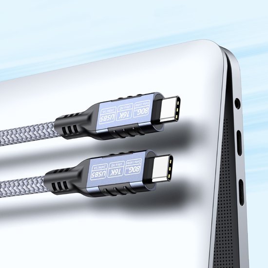 Twee stevige USB-C-kabels met gevlochten omhulsel naast een zilvergrijze laptoppoort