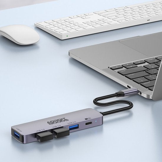 slimme usb-hub aangesloten op laptop met meerdere usb-apparaten en draadloze muis op bureau