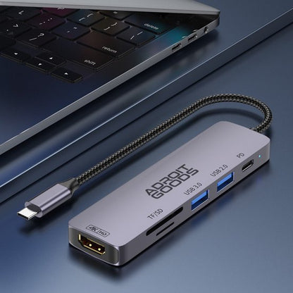 USB-C hub van AdroitGoods met HDMI, TF/SD-kaartlezer en USB 3.0 poorten naast laptop