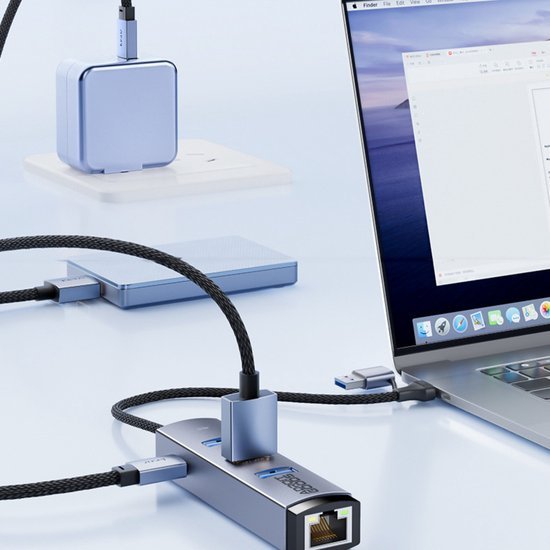 Laptop aangesloten op metalen usb-hub met ethernet, extra kabels en oplader op bureau