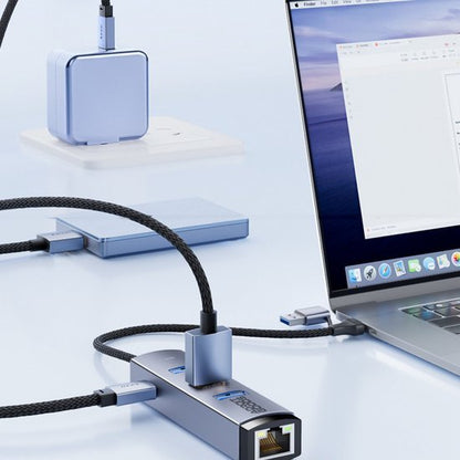 Laptop aangesloten op metalen usb-hub met ethernet, extra kabels en oplader op bureau