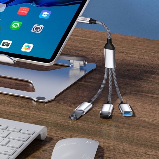 Flexibele multifunctionele USB-hub met drie aansluitingen op een houten bureau naast laptopstandaard