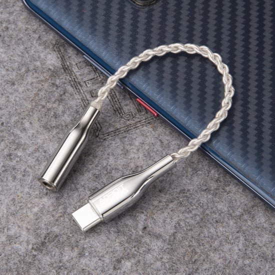 lichtgekleurde gevlochten usb-c naar 3,5 mm audio adapter kabel met metalen behuizing op tafel