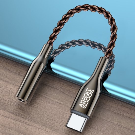 zwarte AdroitGoods adapter met gevlochten kabel op houten oppervlak naast blauw apparaat