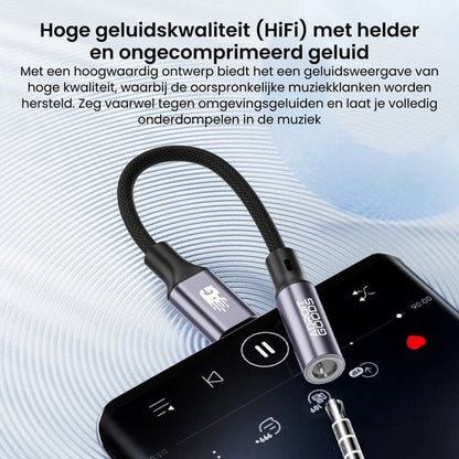 Zilveren audio-adapter met gevlochten kabel aangesloten op smartphone voor muziekweergave