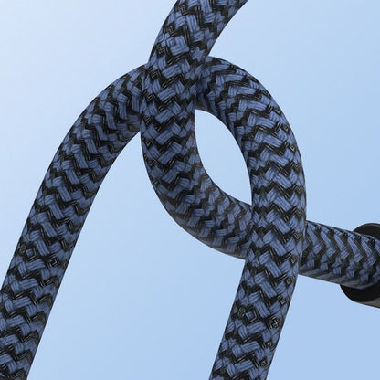 Detail van een zwart-blauw gevlochten kabel tegen een lichte blauwe achtergrond.