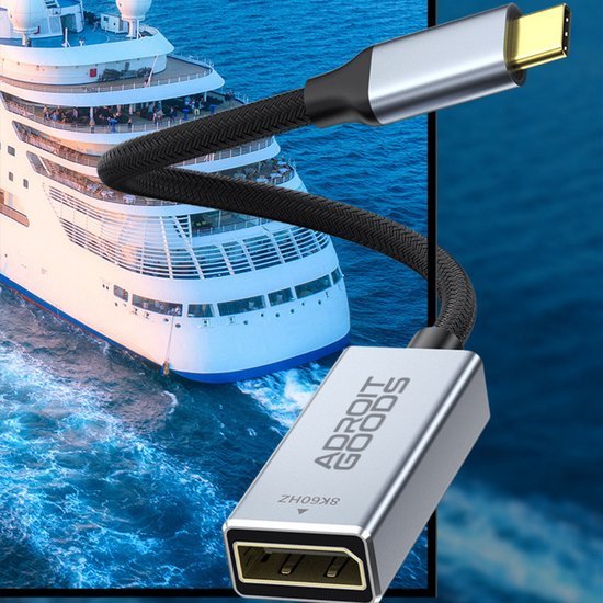 Zilverkleurige USB-C naar USB adapter met gevlochten kabel en schip op achtergrond.