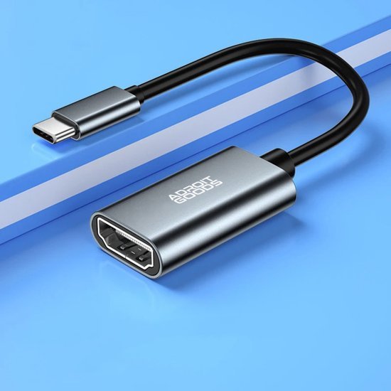 Zilveren USB-C naar HDMI adapter met een kort zwart snoer op een blauwe achtergrond.
