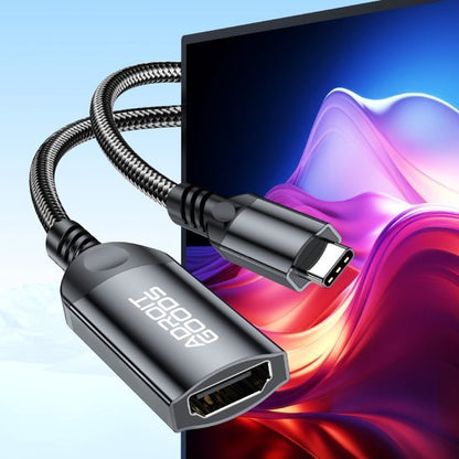 Zwarte gevlochten USB-C naar HDMI kabel aangesloten op een scherm met kleurrijk patroon