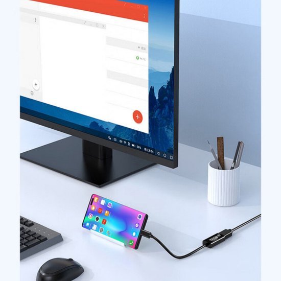 Smartphone verbonden via kabel met monitor op een bureau met muis en pennenhouder