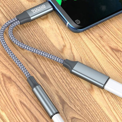 Grijze gevlochten kabel met metalen connectoren verbonden met een smartphone op houten oppervlak