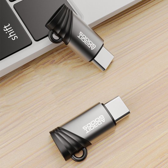 zilverkleurige USB-C adapters van AdroitGoods op houten oppervlak naast laptop toetsenbord