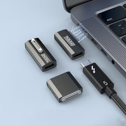 Zwarte magnetische USB-C kabel en adapters aangesloten op een laptoppoort in een nette opstelling.