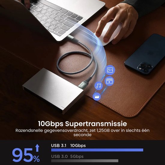 Hand die muis gebruikt bij laptop met snelle gegevenskabel en smartphone op tafel