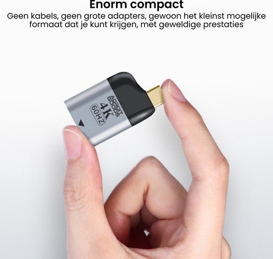 Hand houdt compacte zilvergrijze adapter met goudkleurige connector en zwart topje vast.