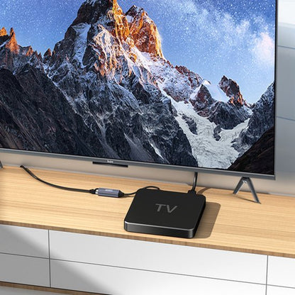 Zwarte mediaspeler aangesloten op flatscreen televisie met berglandschap op het scherm