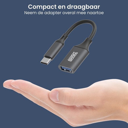 Compacte en draagbare zwarte adapter met USB-C en USB-A aansluiting in handpalm zichtbaar