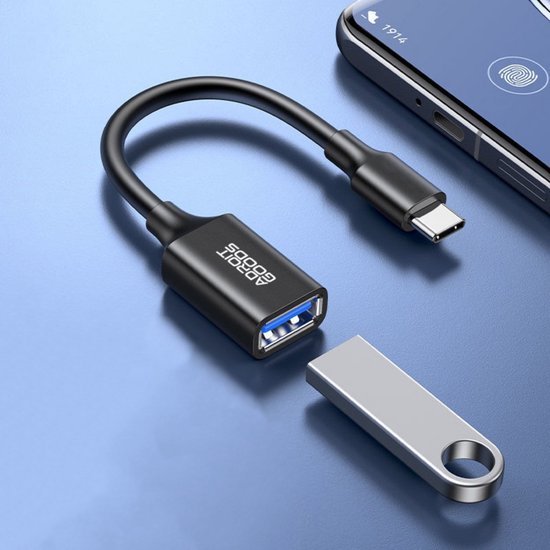 Zwarte USB-C naar USB-A adapterkabel naast een metalen USB-stick op een blauwe ondergrond