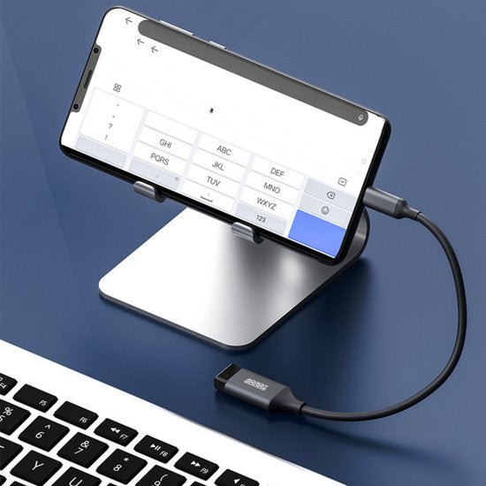 Smartphone geplaatst in een metalen standaard met een kabel aangesloten op een laptop