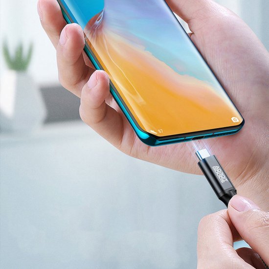 Hand die een lichtblauwe smartphone met gebogen scherm vasthoudt en een kabel aansluit