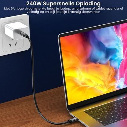 Witte oplader aangesloten op stopcontact met laptop op houten tafel en kleurrijk scherm