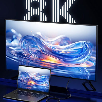 Groot scherm en laptop met helder, abstract beeld in blauw en oranje tinten weergegeven