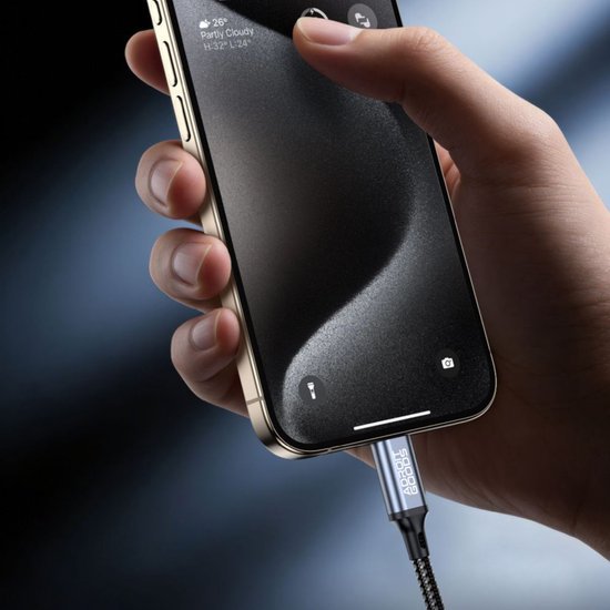 Hand houdt telefoon vast met aangesloten oplaadkabel en donkere minimalistische achtergrond.