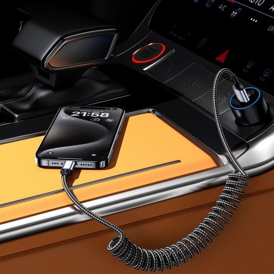 Smartphone opgeladen met een spiraalvormige oplaadkabel in een oranje autointerieur