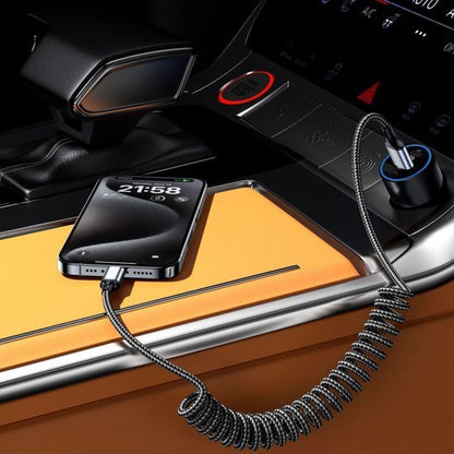 Smartphone opgeladen met een spiraalvormige oplaadkabel in een oranje autointerieur