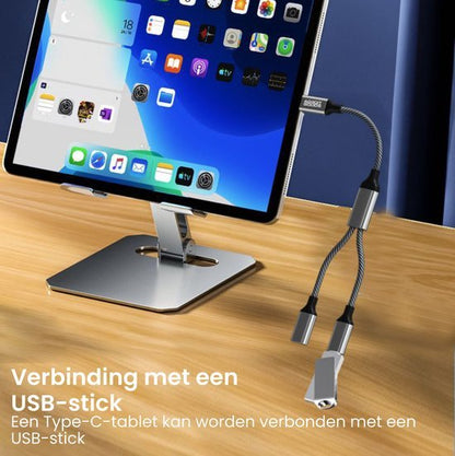 Draadloze USB-C adapter met meerdere aansluitingen op een tablet in zilveren standaardhouder
