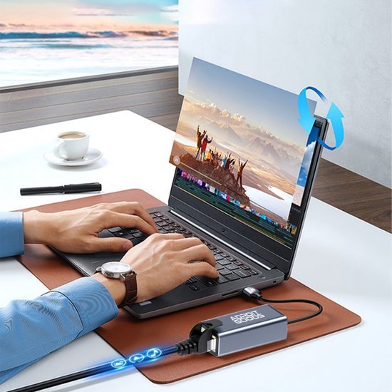 Persoon werkt op laptop met roterend scherm en aangesloten externe AdroitGoods-ssd in moderne kantooromgeving