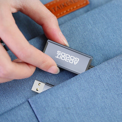 Hand die een grijze AdroitGoods USB-stick uit een blauw stoffen zakje haalt.