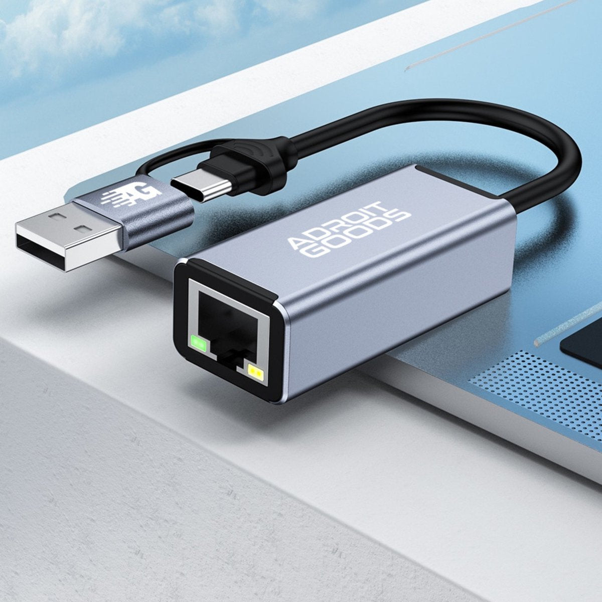 Adapter met USB en ethernet aansluiting naast een laptop op een grijze ondergrond