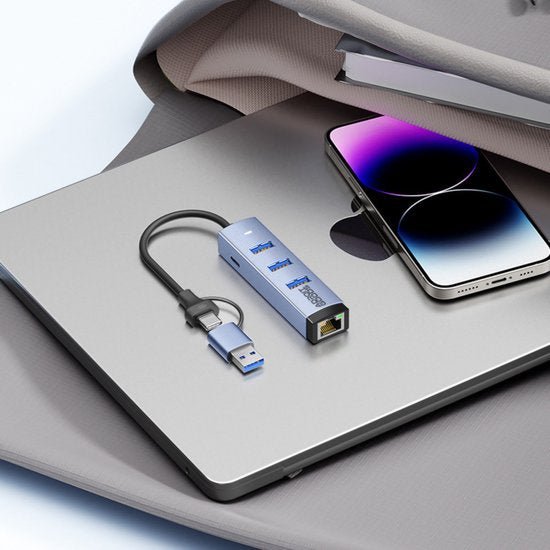 Blauwe USB-hub met meerdere poorten en Ethernet aansluiting naast laptop en smartphone.