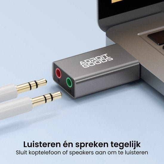 Zilverkleurige adapter met twee audiopoorten aangesloten op een laptop voor geluid en microfoon.
