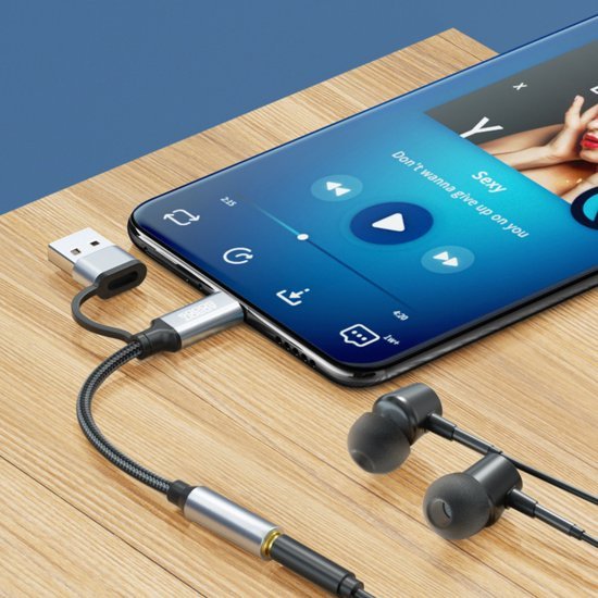 Smartphone verbonden met oortjes via adapter en USB-kabel op houten oppervlak