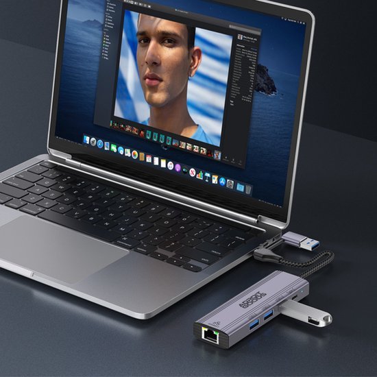 Laptop met foto bewerkingsprogramma en een aangesloten zilveren USB-hub met meerdere poorten