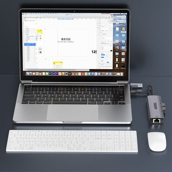Laptop met aangesloten USB-hub, draadloos toetsenbord en draadloze muis op donkere ondergrond