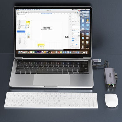 Laptop met aangesloten USB-hub, draadloos toetsenbord en draadloze muis op donkere ondergrond