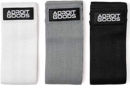 Set van drie AdroitGoods fitness weerstandsbanden in wit, grijs en zwart, netjes gerangschikt.