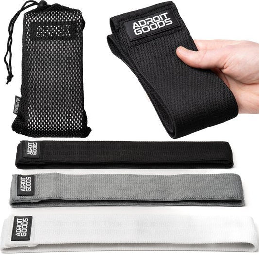 Set van drie weerstandsbanden in zwart, grijs en wit met draagtas en hand die zwarte band vasthoudt